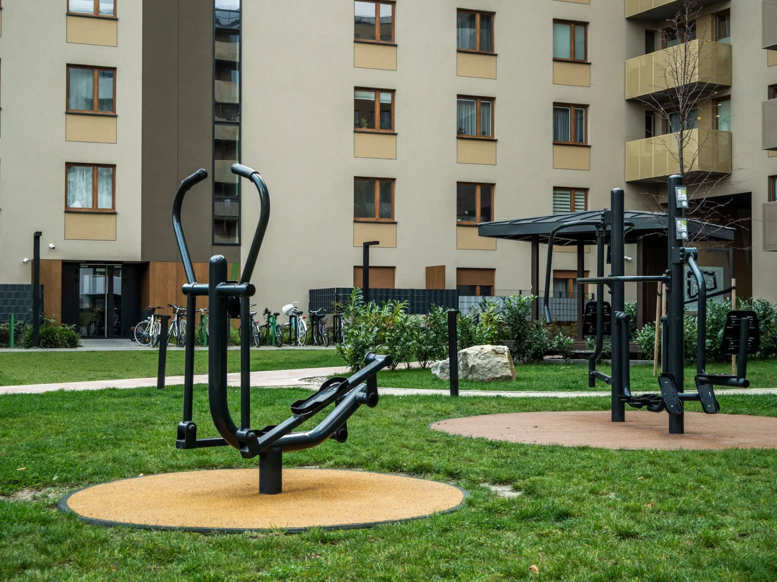 Modern outdoor gym equipment in a residential courtyard, promoting fitness and healthy lifestyle.